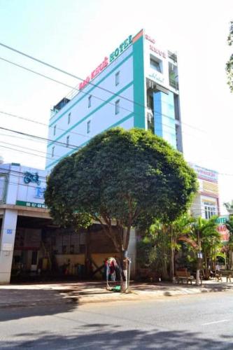 a building with a tree in front of a building at Sao Khue Hotel in Buon Ma Thuot