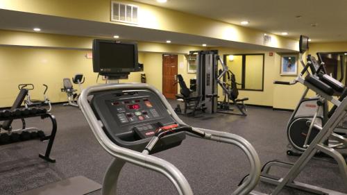 a room with a gym with machines and a tv at Astoria Hotel & Event Center in Dickinson