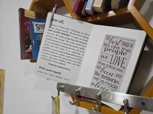 a book is hanging on a shelf with books at BEE HAPPY Hostel in Dalandzadgad