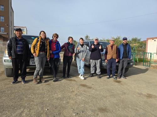 a group of people standing in front of a car at BEE HAPPY Hostel in Dalandzadgad