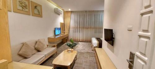 a living room with a couch and a tv at Tuong Vi Hotel in Hai Phong