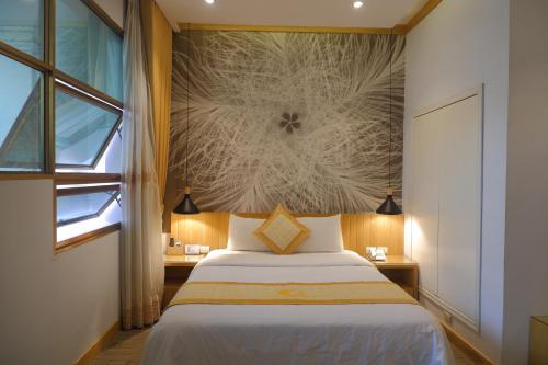 a bedroom with a bed and a wall mural at Tuong Vi Hotel in Hai Phong