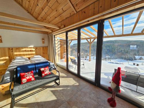 a bedroom with a bed and a large window at Chata w Bieszczadzie apartamenty i domki z basenem Bieszczady in Polańczyk
