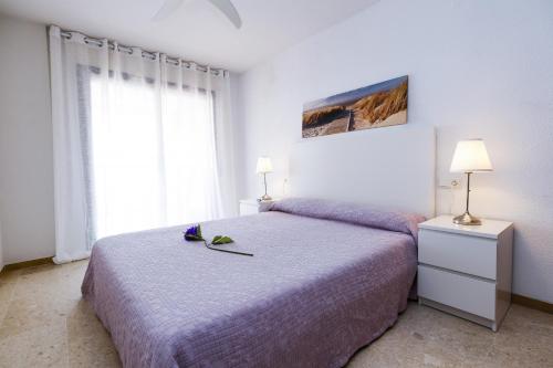 1 dormitorio con 1 cama con sábanas moradas y 2 lámparas en PLAYALARGA 2 - Planet Apartment, en Salou