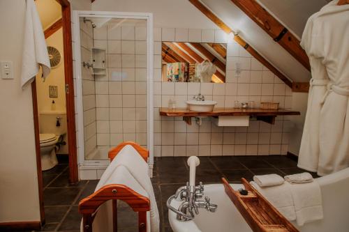 a bathroom with a tub and a sink at Aan de Oever Guesthouse in Swellendam