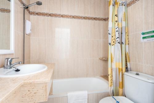 a bathroom with a sink and a toilet and a shower at Apartamentos Alta Galdana in Cala Galdana