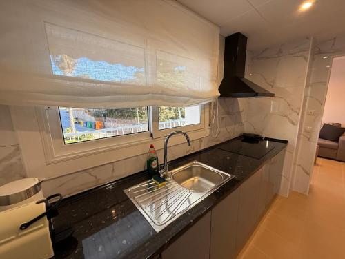 un comptoir de cuisine avec un évier et une fenêtre dans l'établissement Lloret de Mar Coastal Retreat Just Steps from the Beach, à Lloret de Mar