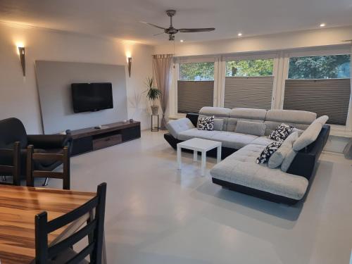 a living room with couches and a flat screen tv at Moderne Traum-Ferienwohnung Flughafen und Zentrumsnah in Hamburg