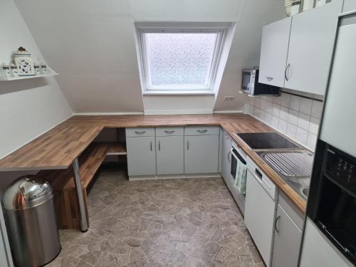 a kitchen with white cabinets and a wooden counter top at Moderne Traum-Ferienwohnung Flughafen und Zentrumsnah in Hamburg