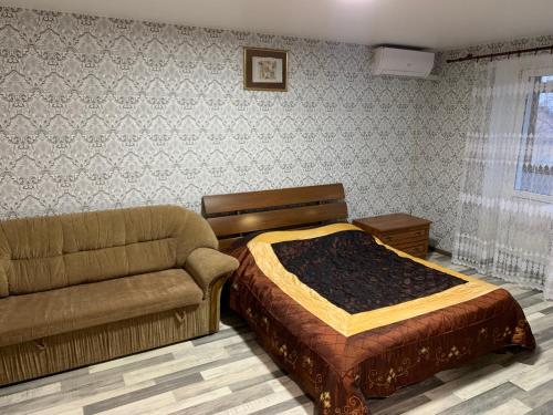 a bedroom with a bed and a couch at APARTMENT PREMIUM VIP in Berdychiv