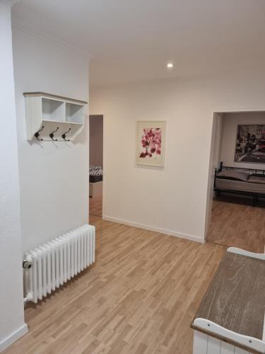 a living room with white walls and wooden floors at Moderne Traum-Ferienwohnung Flughafen und Zentrumsnah in Hamburg