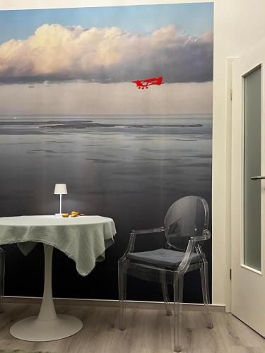 a room with a table and a red plane flying over the water at Altstadtnest in Greifswald
