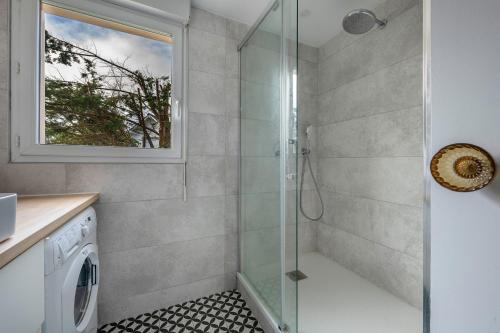 une salle de bain avec douche et machine à laver dans l'établissement La Baule, appartement confortable pour 4, à Pornichet
