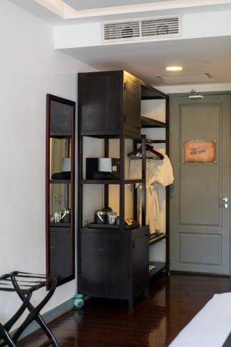 a room with a black book shelf with pots and pans at Souphattra Hotel Luang Prabang in Luang Prabang