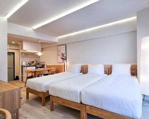 a bedroom with two beds and a table and a kitchen at STAY ARI Kabukicho in Tokyo