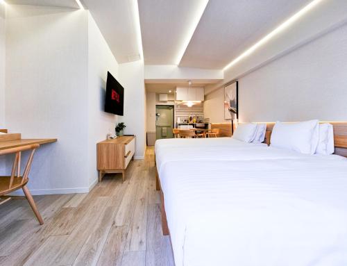 a bedroom with a large white bed and a desk at STAY ARI Kabukicho in Tokyo