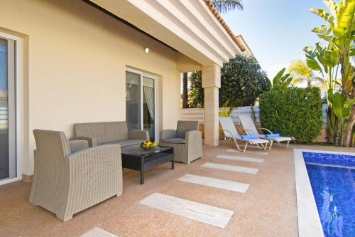 a patio with chairs and a swimming pool at Villa Alyson in Paralimni