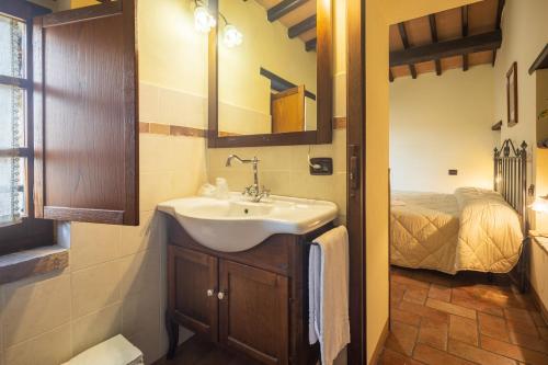 a bathroom with a sink and a bed at Casale delle Lucrezie by VacaVilla in Due Santi