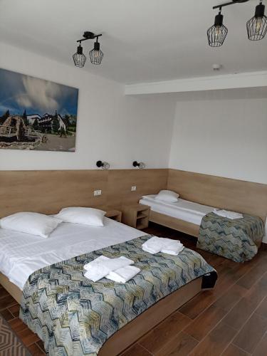 a bedroom with two beds with towels on them at Club Vila Bran in Bran