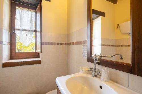 a bathroom with a sink and a window at Casale delle Lucrezie by VacaVilla in Due Santi