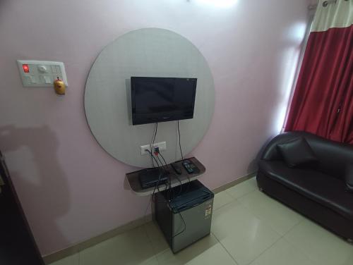 a room with a mirror and a tv and a couch at Hotel Viraat Inn in Gaya