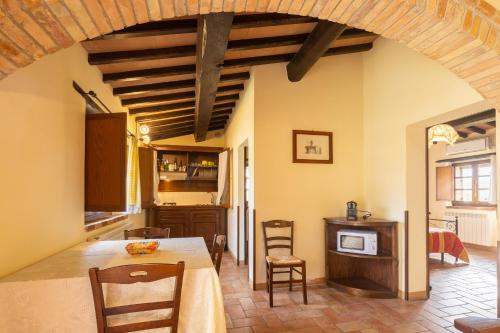 a kitchen and dining room with a table and chairs at Casale delle Lucrezie by VacaVilla in Due Santi