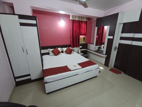 a bedroom with a large bed with red walls at Hotel Viraat Inn in Gaya