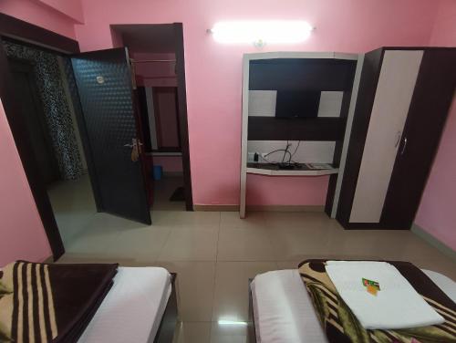 a small room with two beds and a mirror at Hotel Viraat Inn in Gaya
