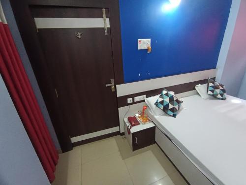 a small room with a bed and a door at Hotel Viraat Inn in Gaya
