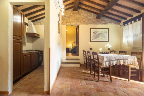 a kitchen and dining room with a table and chairs at Casale delle Lucrezie by VacaVilla in Due Santi