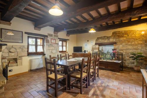 a dining room with a wooden table and chairs at Casale delle Lucrezie by VacaVilla in Due Santi
