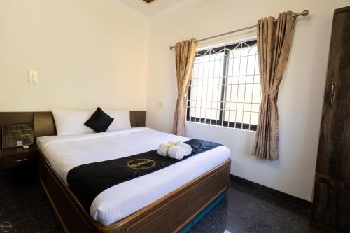 a bedroom with a bed with a stuffed animal on it at Reunion Charm Villa in Udupi