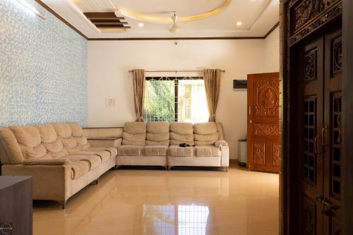 a living room with two couches and a window at Reunion Charm Villa in Udupi