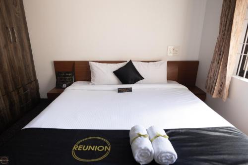 a bed with two pairs of shoes sitting on it at Reunion Charm Villa in Udupi