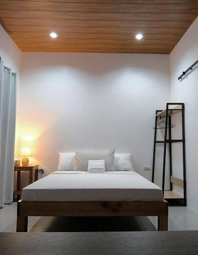 a bedroom with a bed with a wooden ceiling at Casa Marilag Guest House in Siquijor