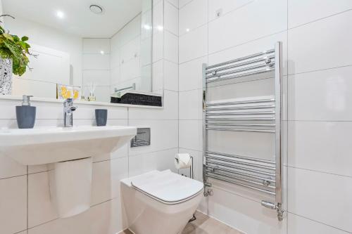 a white bathroom with a toilet and a sink at Luxurious 3 Bed Townhouse Bham Centre in Birmingham