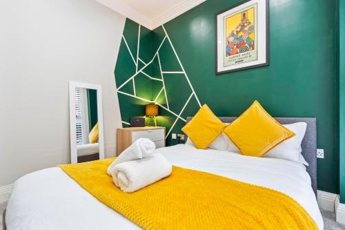 a bedroom with a large bed with a yellow blanket at Luxurious 3 Bed Townhouse Bham Centre in Birmingham