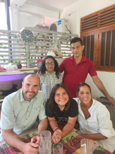 a group of people posing for a picture at a table at Rai Family Guest in Matara
