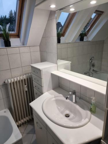 a white bathroom with a sink and a mirror at Moderne Traum-Ferienwohnung Flughafen und Zentrumsnah in Hamburg