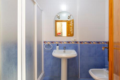 un bagno blu e bianco con un lavandino e uno specchio di Maracas 1 a El Pozo de los Frailes