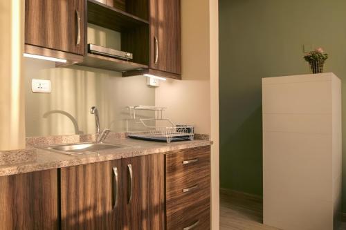 a kitchen with a sink and a refrigerator at 46 Serviced Apartments in Amman