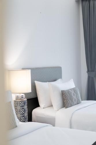 a room with two beds and a couch and a lamp at Souphattra Hotel Luang Prabang in Luang Prabang