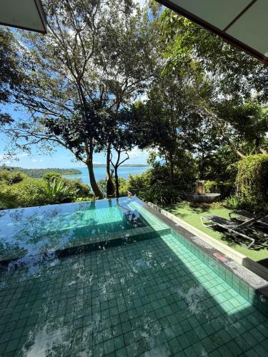 a swimming pool with a view of the ocean at Ambong Pool Villas - Private Pool in Pantai Cenang