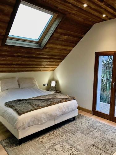 une chambre avec un grand lit avec une fenêtre dans l'établissement Villa à 200mètres du lac avec terrasse privée, à Sévrier