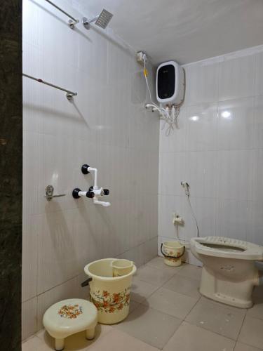 a bathroom with two toilets and a tv on the wall at Sea View Villa in Kondivli