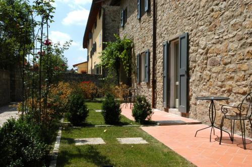 a garden with a table and chairs next to a building at Palazzo Loup Hotel in Loiano