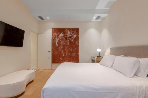 - une chambre avec un grand lit blanc et un tableau dans l'établissement Chic 7th Elegance, à Paris