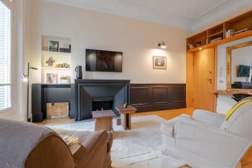 un salon avec un canapé et une cheminée dans l'établissement Chic 7th Elegance, à Paris