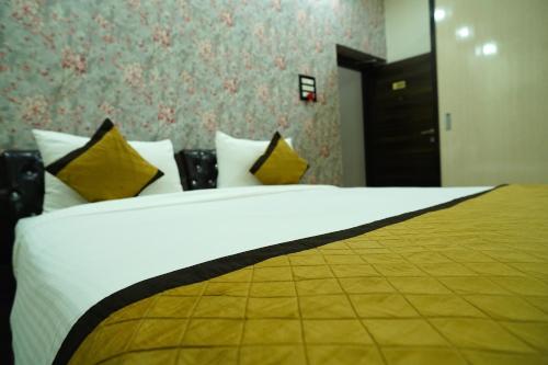 a bedroom with a large white bed with yellow pillows at THE MANTRA- A Luxury Boutique Hotel in Khagaul