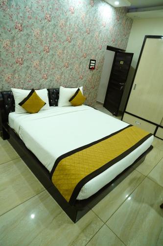 a bedroom with a large bed with yellow pillows at THE MANTRA- A Luxury Boutique Hotel in Khagaul